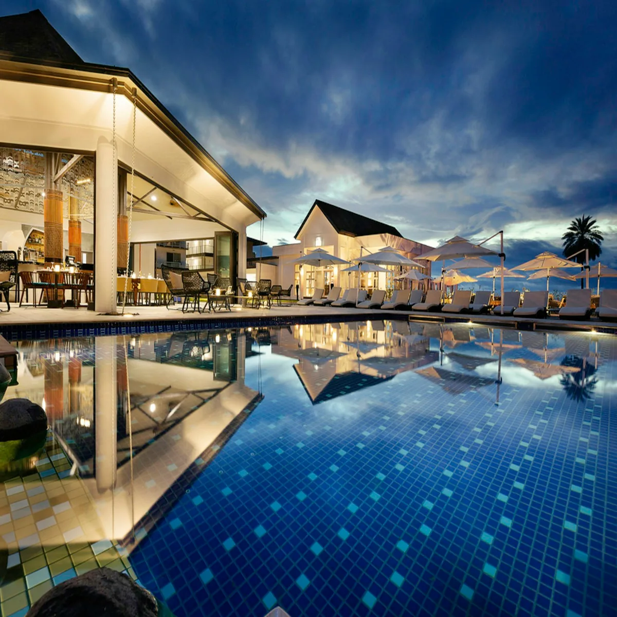A Caribbean-style resort pool surrounded by palms