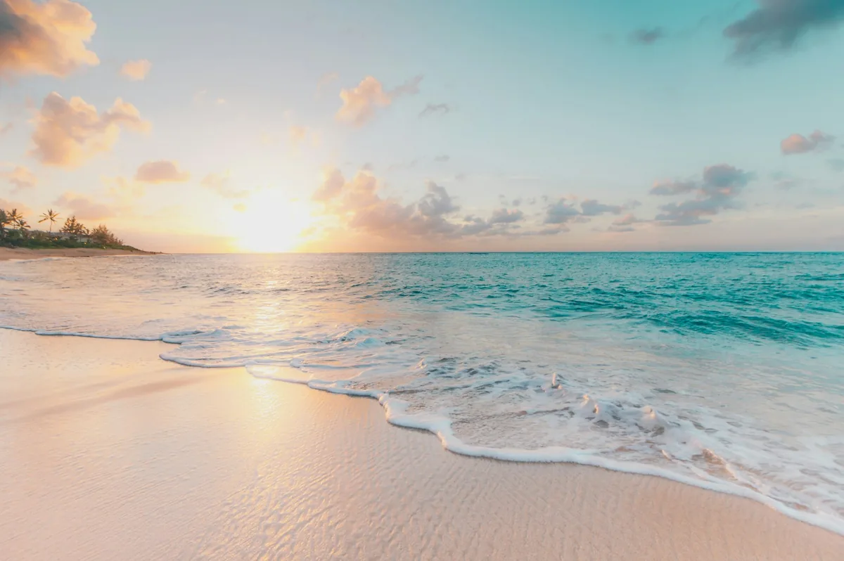 A calm tropical beach with bright water and soft sand